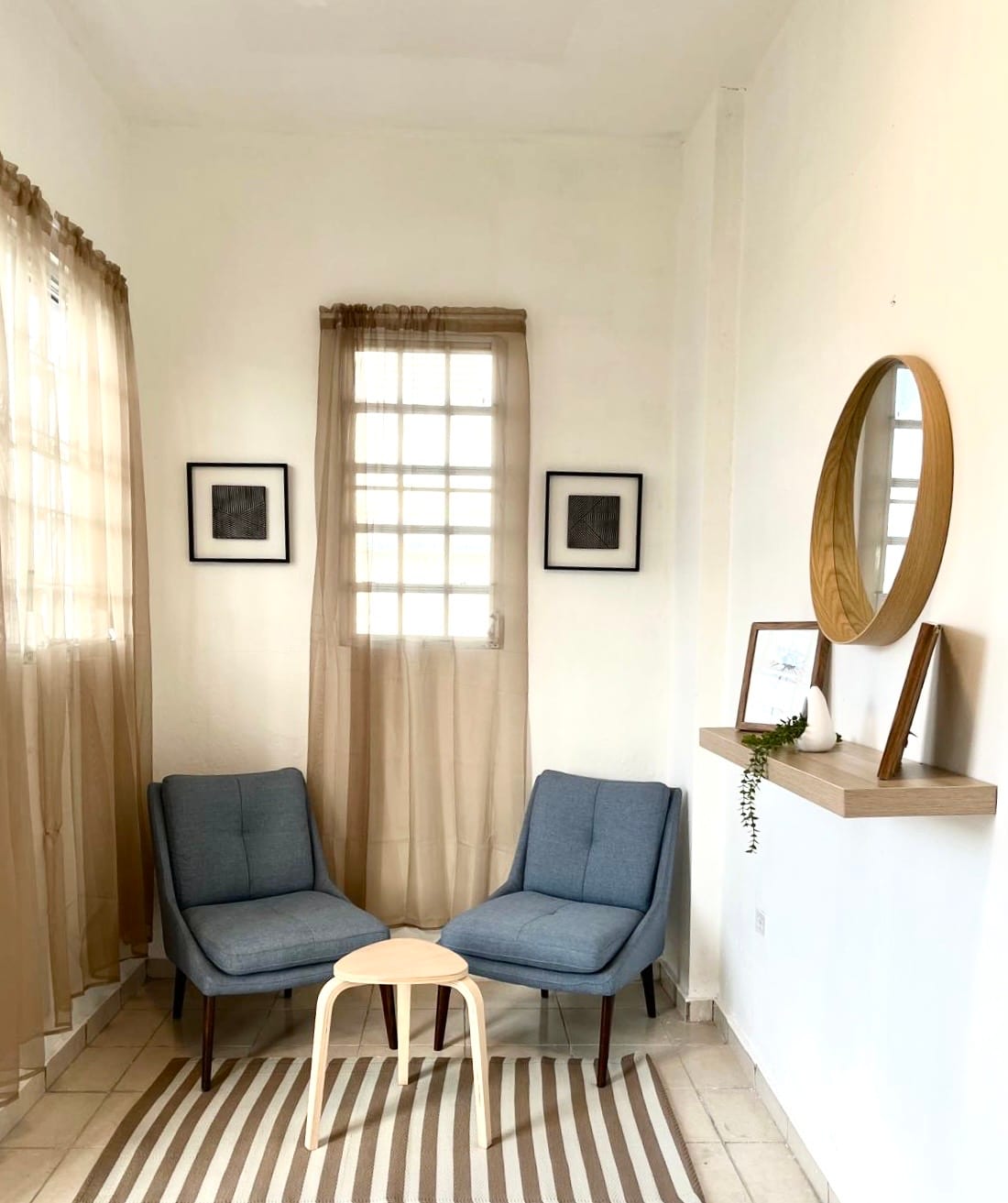 Styled sitting nook with linen curtains and round oak mirror
